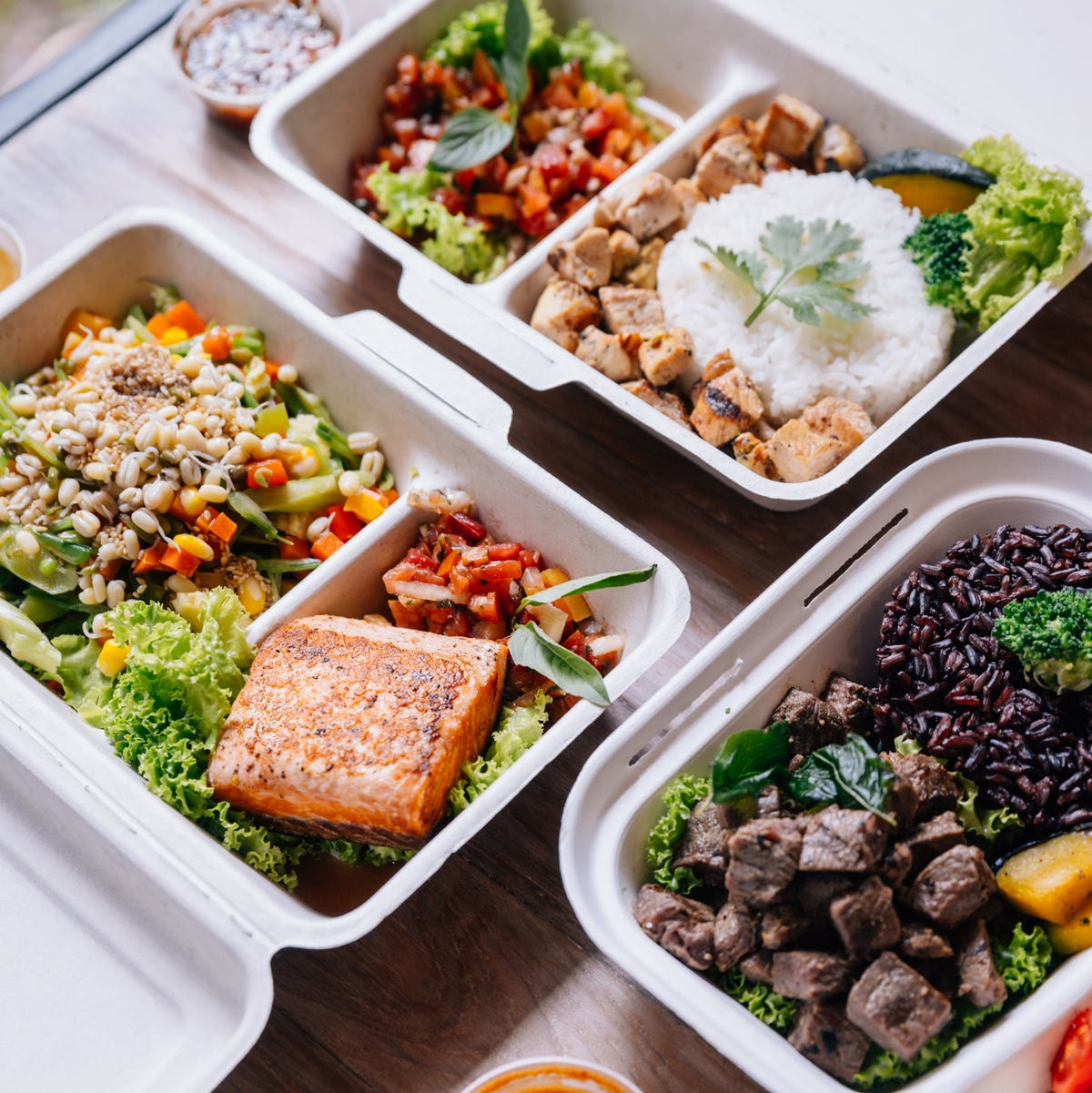 Balanced meal prep containers with protein-rich foods like grilled salmon, chicken, beef, rice, and vegetables for post-workout nutrition and muscle recovery