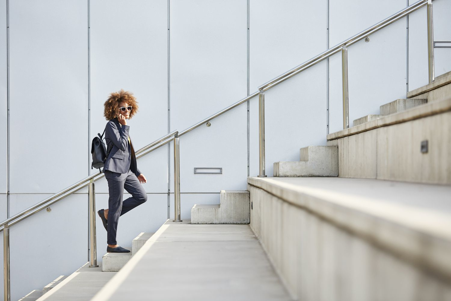 A woman confidently climbing modern stairs, illustrating stair climbing as a healthy daily activity