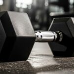 Hex Dumbbell 7.5kg: Complete Buyer's Guide & Reviews Close-up of a single 7.5 kg hex dumbbell resting on a gym floor, with a knurled chrome handle and blurred workout equipment in the background.