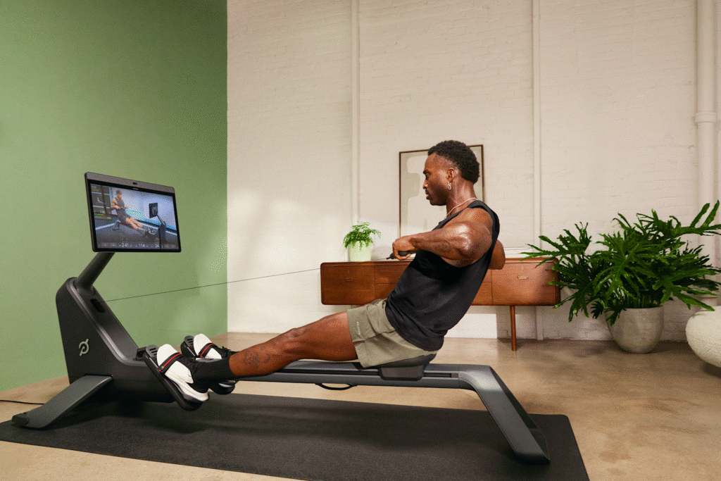 Person exercising on rowing machine indoors.
